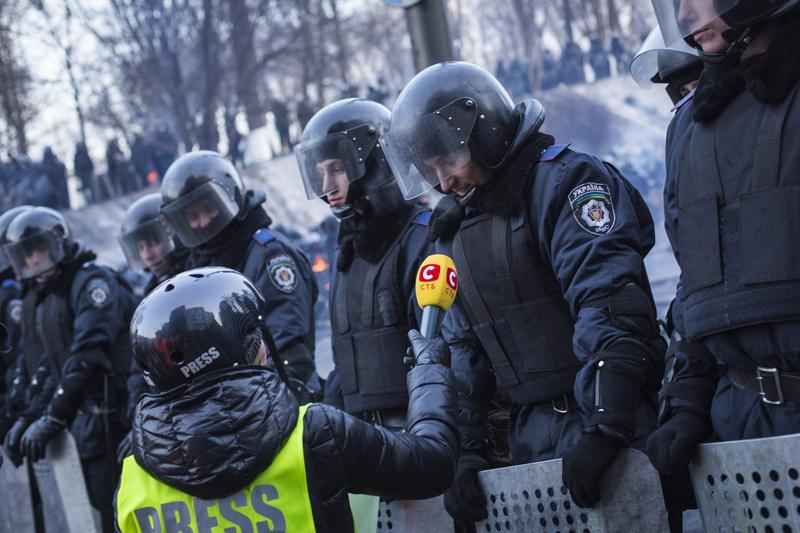 A Ukrainian policeman speaks to a journalist on Grushevskogo Street on January 27, 2013 in Kiev, Ukraine.
