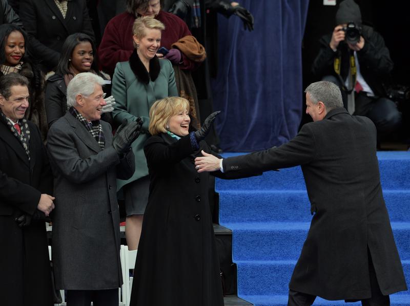 Newly sworn in New York City Mayor Bill de Blasio (right) walks to hug Hillary Rodham Clinton (center) on the steps of City Hall in Lower Manhattan January 1, 2014 in New York.