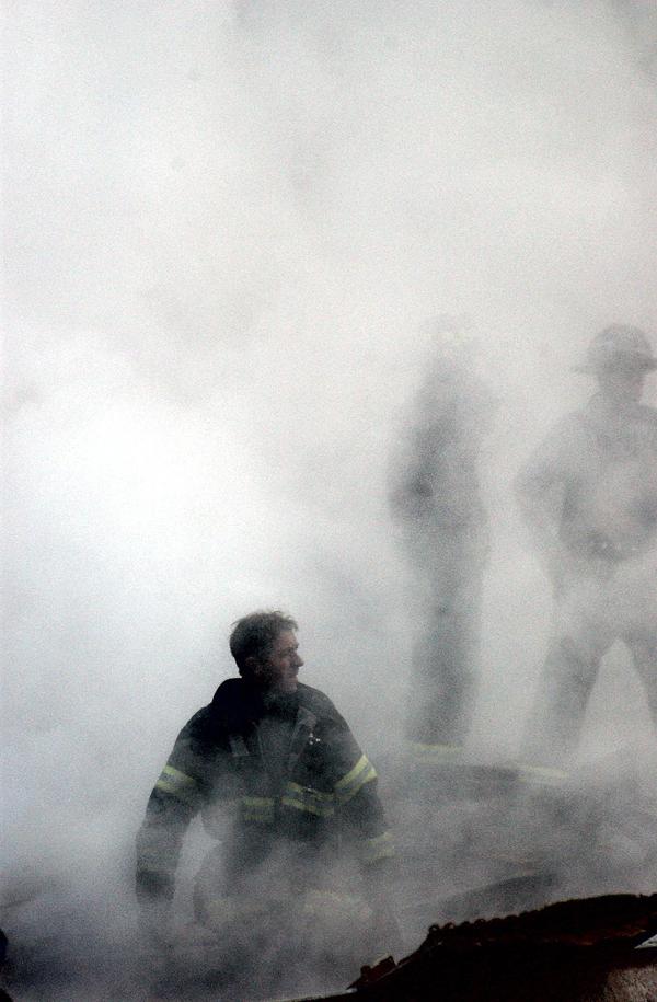 This US Navy photo released 17 September, 2001, shows a firefighter emerging from the smoke and debris of the World Trade Center September 14, 2001.