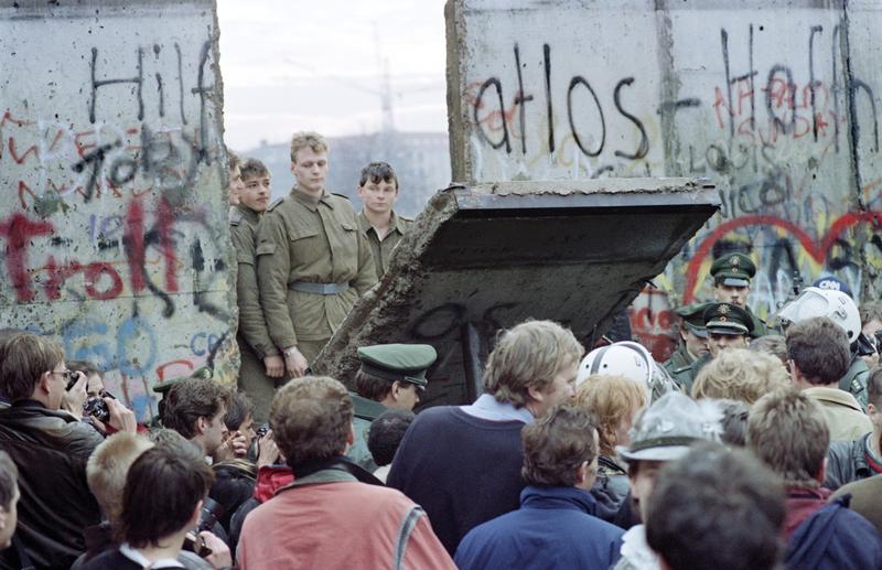 West Berliners crowd in front of the Berlin Wall on Nov. 11, 1989 as they watch East German border guards demolishing a section of the wall to open a new crossing point between East and West Berlin.