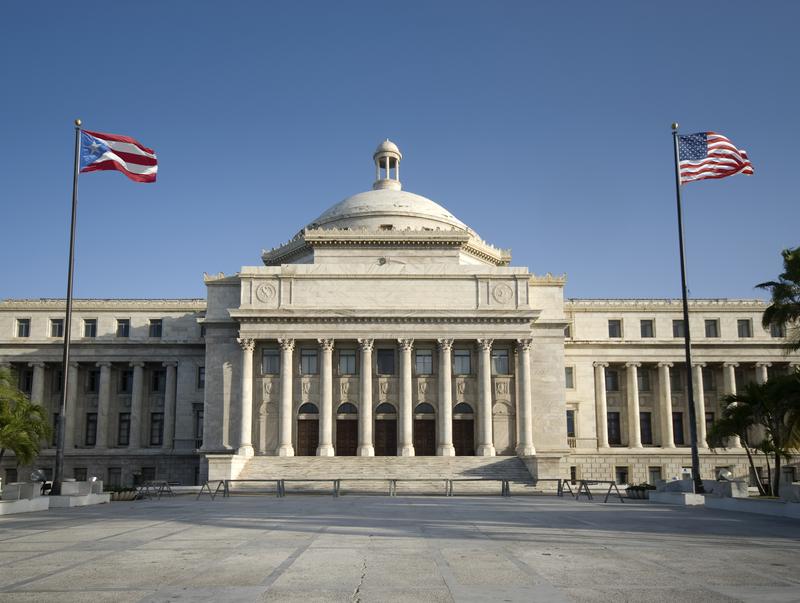 Puerto Rican and American flags frame the Puerto Rican capitol building.