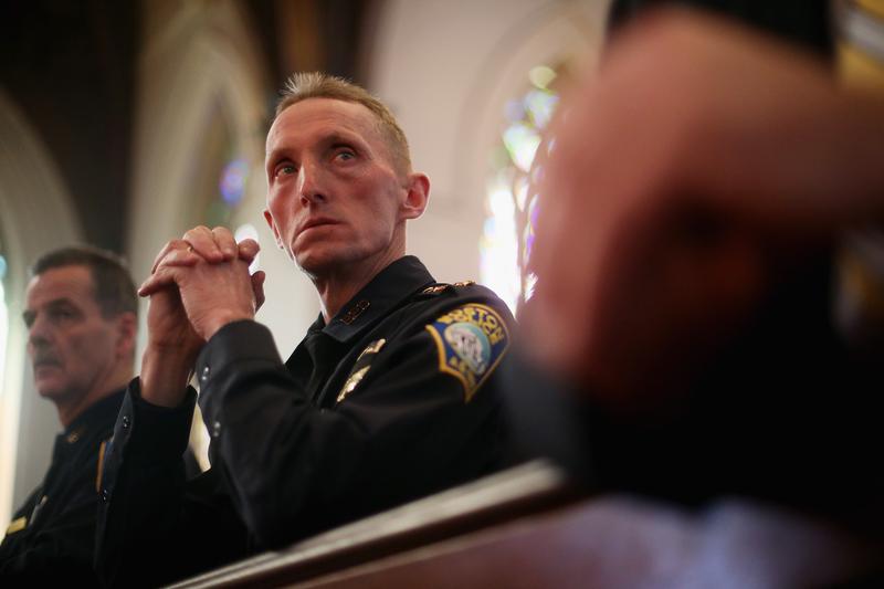 Then-Boston Police Department Superintendent William Evans (C) and Kevin Buckley (L) attend mass at the Cathedral of the Holy Cross on the first Sunday after the marathon bombings on April 21, 2013.