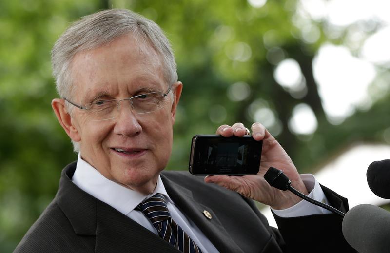 Senate Majority Leader Harry Reid plays a song by musician Neil Young on his iPhone while participating in a news conference emphasizing the need for Congress to pass the Farm Bill September 9, 2013.