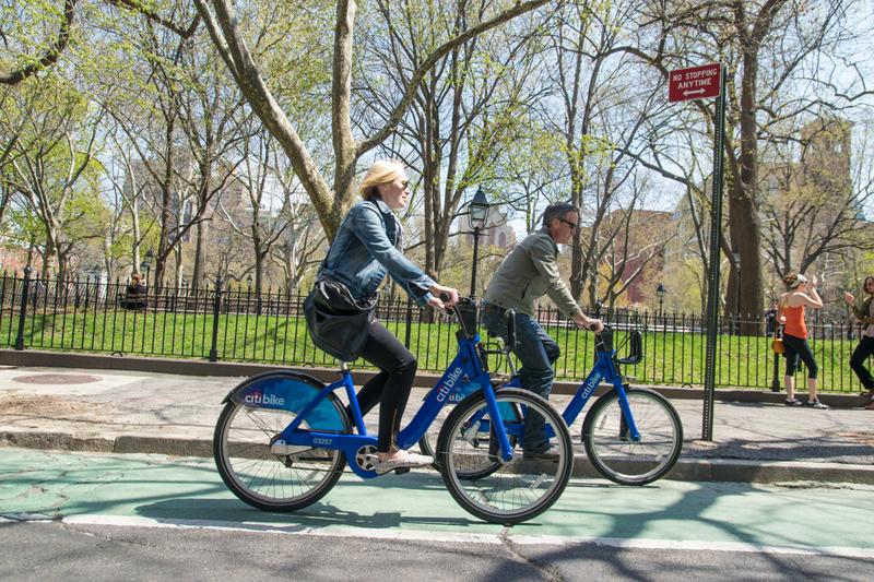 Cyclists ride Citi Bikes past Washington Square Park in late April.
