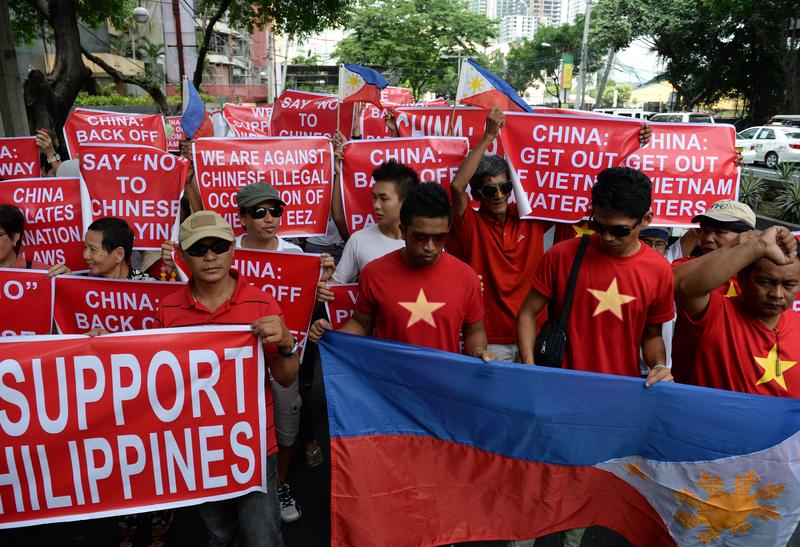 Philippine and Vietnamese protesters hold placards as they shout slogans during an anti-China protest in front of the Chinese consulate in the financial district of Manila on May 16, 2014.