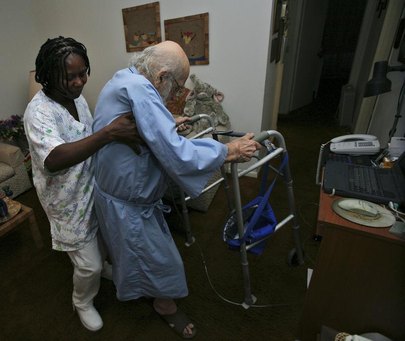Nurse's aide Anelia Santfleur helps Martin Hornung, 86, at his home in Boca Raton, Florida.