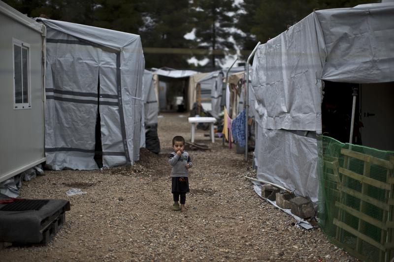 A Syrian refugee child walks between shelters at the refugee camp of Ritsona about 86 kilometers (53 miles) north of Athens, Wednesday, Dec. 28, 2016. 