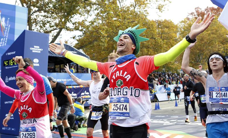 Runners react as they cross the finish line at the New York City Marathon in New York, Sunday, Nov. 1, 2015