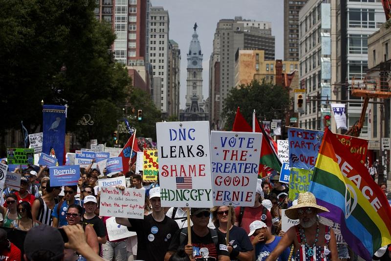People march protecting the DNC email wikileaks scandal and holding signs in support of former Democratic presidential candidate Bernie Sanders during a protest at the 2016 DNC.