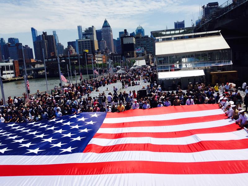 Unfurling of the flag at a memorial service outside the USS Intrepid