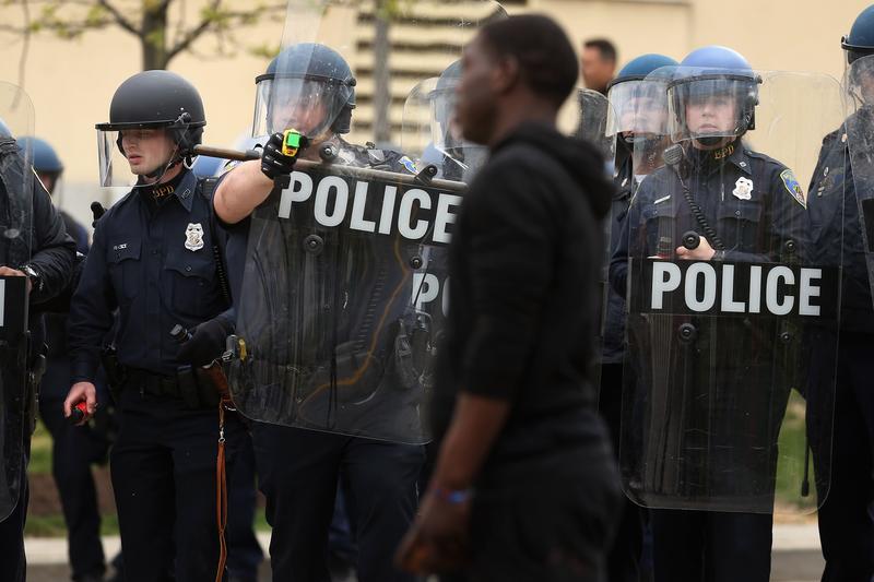 A Baltimore Police officer aims his taser at a demonstrator outside the Mondawmin Mall following the funeral of Freddie Gray April 27, 2015 in Baltimore, Maryland.