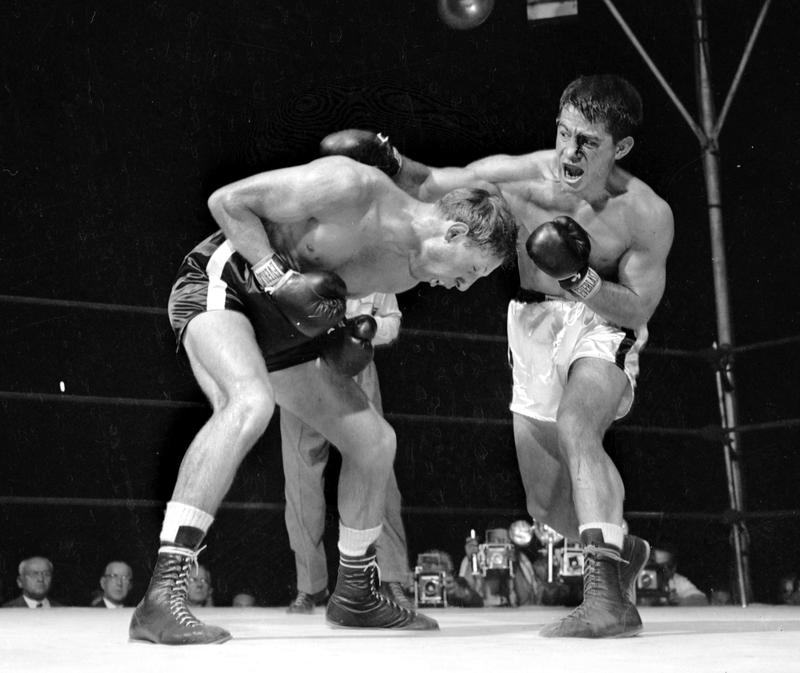 Rocky Graziano throws one of his vicious rights in the second round as Charley Fusari does a neat piece of ducking, September 14, 1949.