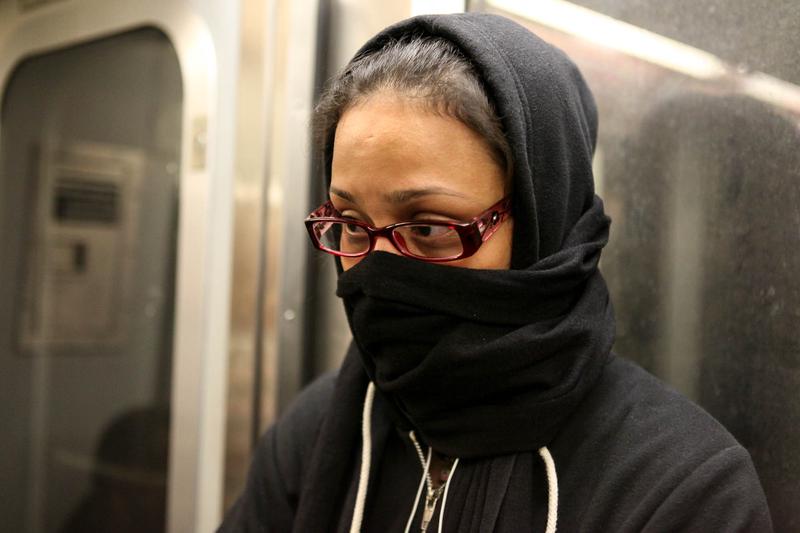 A woman on the L train covers her face, fearful after a doctor with Ebola rode the train.