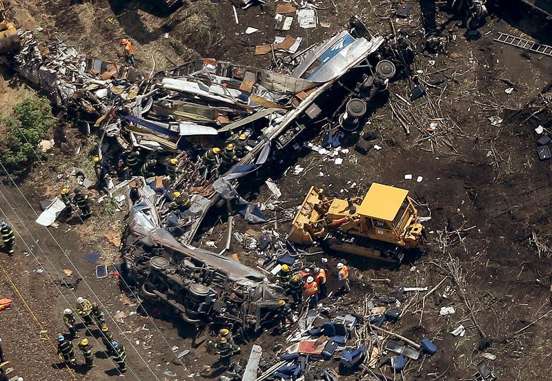 Investigators and first responders work near the wreckage of an Amtrak passenger train carrying more than 200 passengers from Washington, DC to New York that derailed May 13, 2015 in Philadelphia, PA.