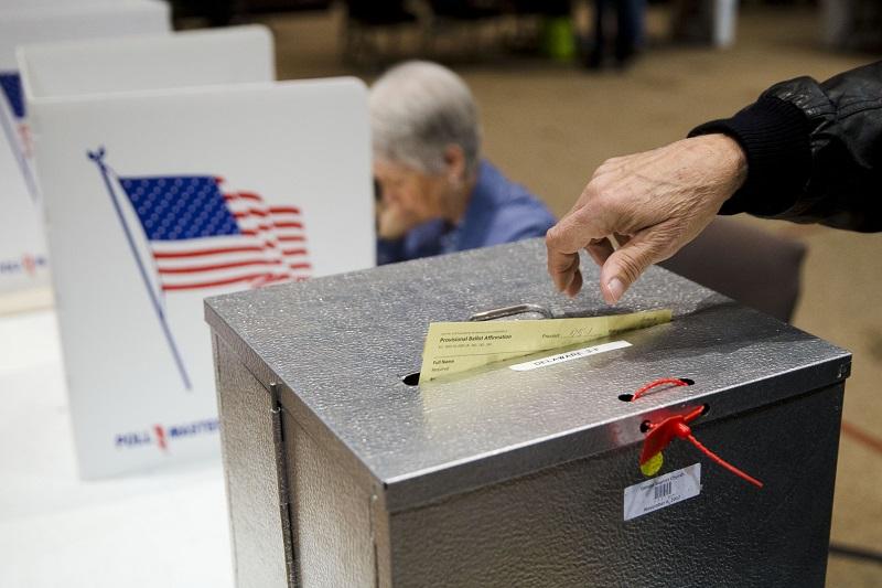 In this March 15, 2016, file photo, a primary election voter casts a provisional ballot at a polling place in Westerville, Ohio.