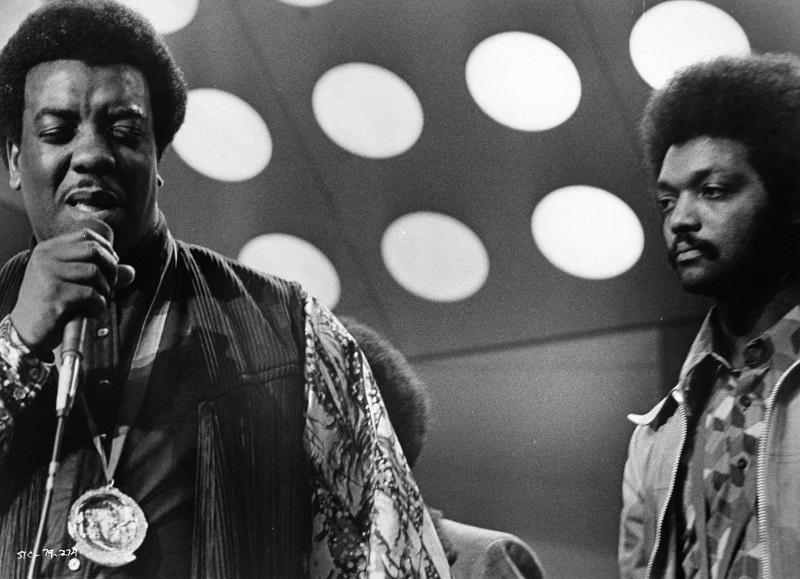 (L-R) Gospel singer Reverend James Cleveland and Reverend Jesse Jackson perform onstage at the PUSH 'Save The Children' concert in a film still from the 1973 movie of the same name.