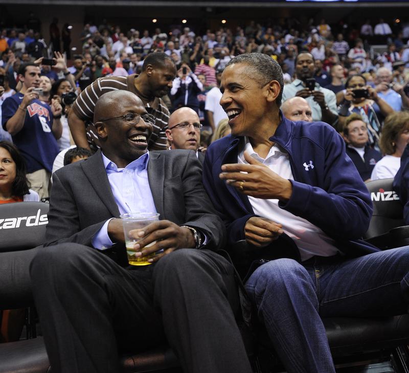 U.S. President Barack Obama shares a laugh with former White House aide Reggie Love as they watch the US Senior Men's National Team and Brazil play during a pre-Olympic exhibition basketball game.