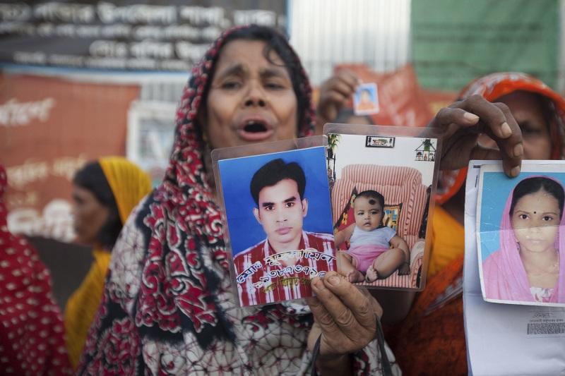 Relatives of the victims of the April 24 Rana Plaza building collapse display photographs of their dear ones as they gather to pay tributes at the venue of the tragedy at Savar, outskirts of Dhaka.
