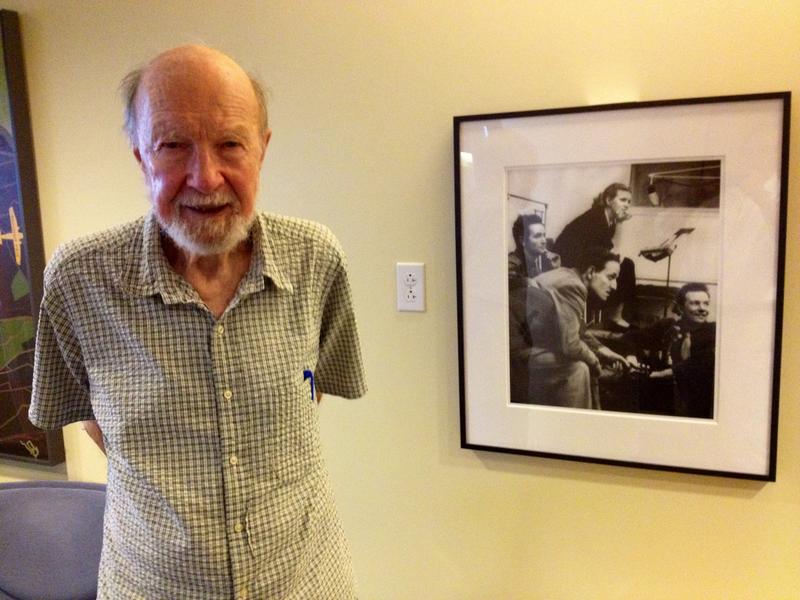 Pete Seeger at WNYC in 2012, next to a picture of himself at WNYC in 1941