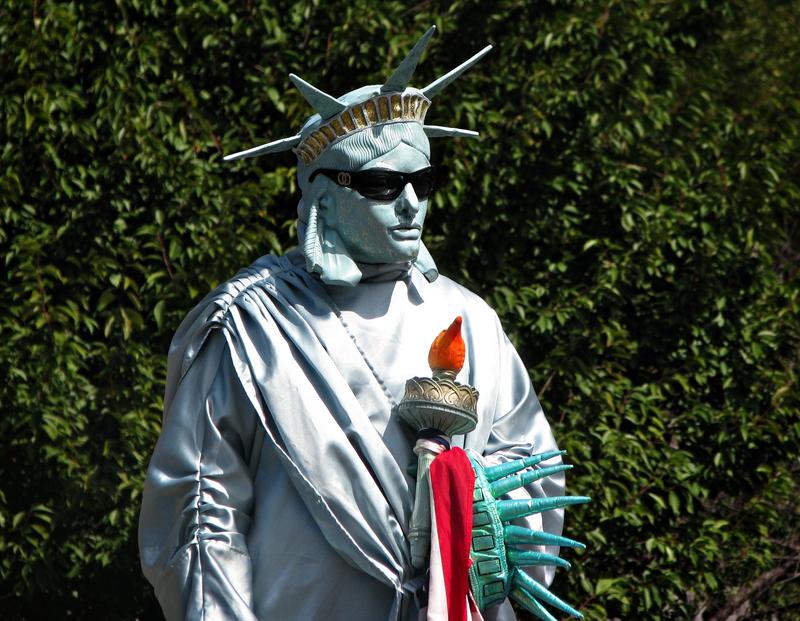 A man poses as Lady Liberty in exchange for photos - and money - in New York City.