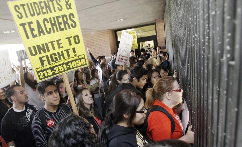 Pounding on the temporarily-closed gates of the student administrative center, college students, faculty and staff of the California State University system protest state budget cuts, 4/13/2011.