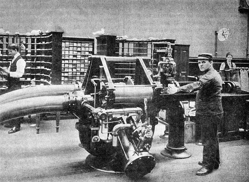 Photograph showing an operator preparing to feed a carrier holding about 500 letters into the transmitter for dispatch through the tube from Brooklyn Post Office to New York General Post Office.