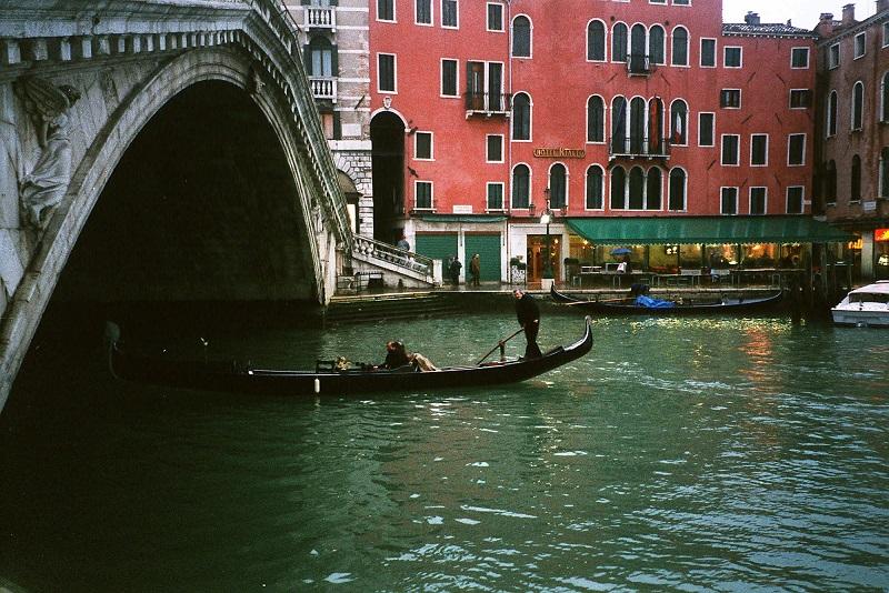 A gondola plies the waters of the Grand Canal, heading under the Ponte del Rialto, free of summer's heavy tourist traffic. 