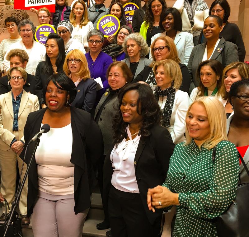Assembly Member Latrice Walker (lower left, with microphone) and women lawmakers and advocates call on Gov. Cuomo to make good on his pledge to expand voter rights in New York.