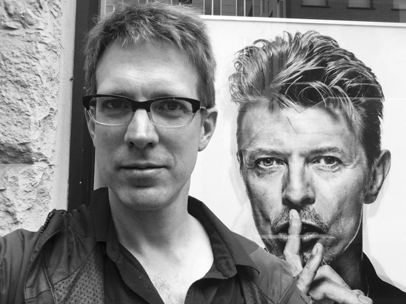 Shearwater's Jonathan Meiburg and a poster of David Bowie