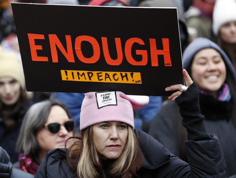A woman holds a sign expressing her opinion about impeaching President Donald Trump at a rally organized by Women's March NYC at Foley Square in Lower Manhattan, Saturday, Jan. 19, 2019, in New York.