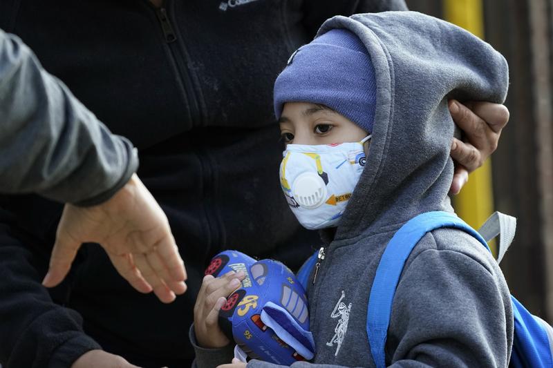 A teacher reaches her hand out to Pedro Garcia, 4, as he arrives for the first day of school at the Mosaic Pre-K Center in Queens, Monday, Sept. 21, 2020 in New York.
