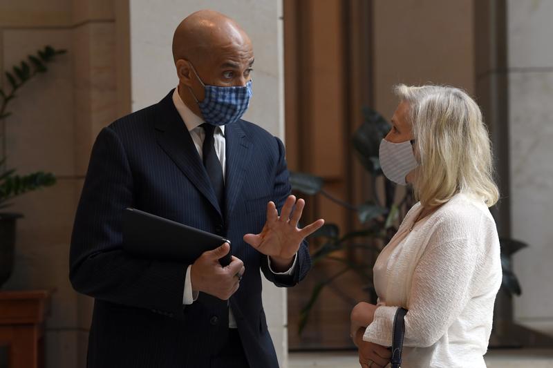 Sen. Cory Booker, D-N.J.,, left, talks with Sen. Kirsten Gillibrand, D-N.Y., following a moment of silence on Capitol Hill in Washington, Thursday, June 4, 2020, to commemorate the life of George Floy