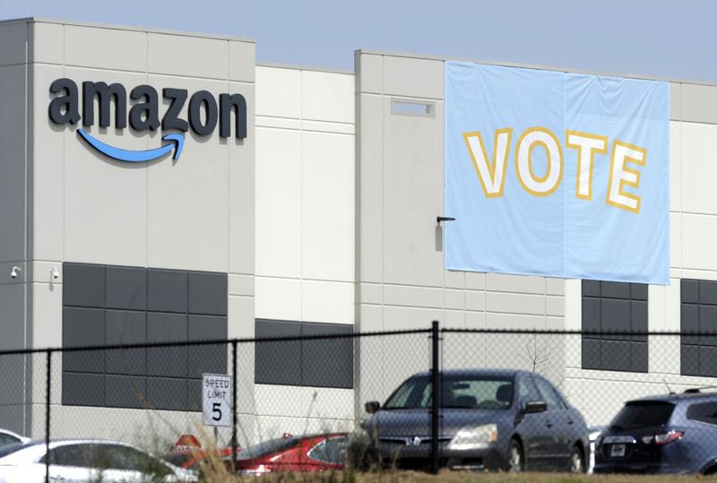 In this March 30, 2021 file photo, a banner encouraging workers to vote in labor balloting is shown at an Amazon warehouse in Bessemer, Ala.