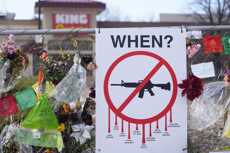 Tributes hang on the temporary fence surrounding the parking lot in front of a King Soopers grocery store in which 10 people died in a late March mass shooting