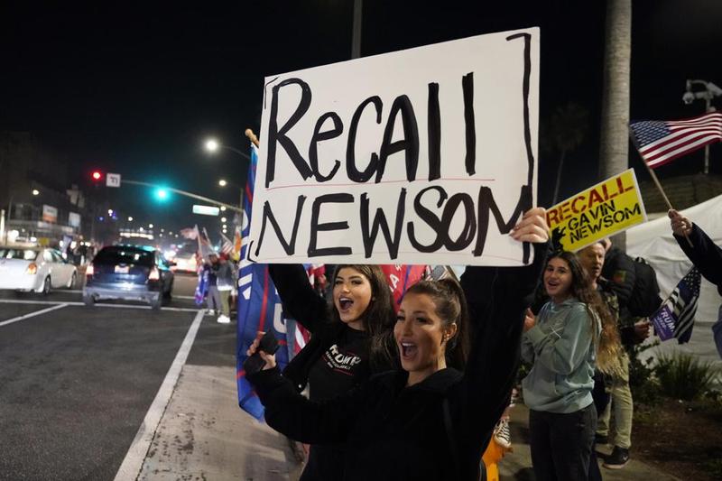 In this Nov. 21, 2020, file photo, demonstrators shout slogans while carrying a sign calling for a recall on Gov. Gavin Newsom during a protest against a stay-at-home order amid the COVID-19 pandemic.