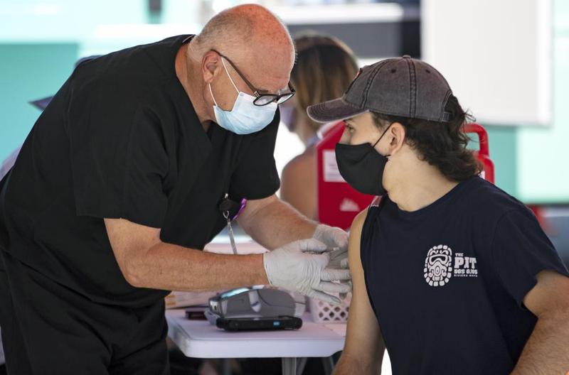 A person getting a Johnson & Johnson vaccine by a health care worker at the one-time pop-up vaccination site located 16th Street beach on the sand on Sunday, May 2, 2021 in Miami Beach.