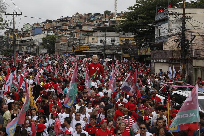 A large doll in the likeness of Brazil's former President Luiz Inacio Lula da Silva, who is running for office again, is paraded through the Complexo do Alemao favela at his campaign rally