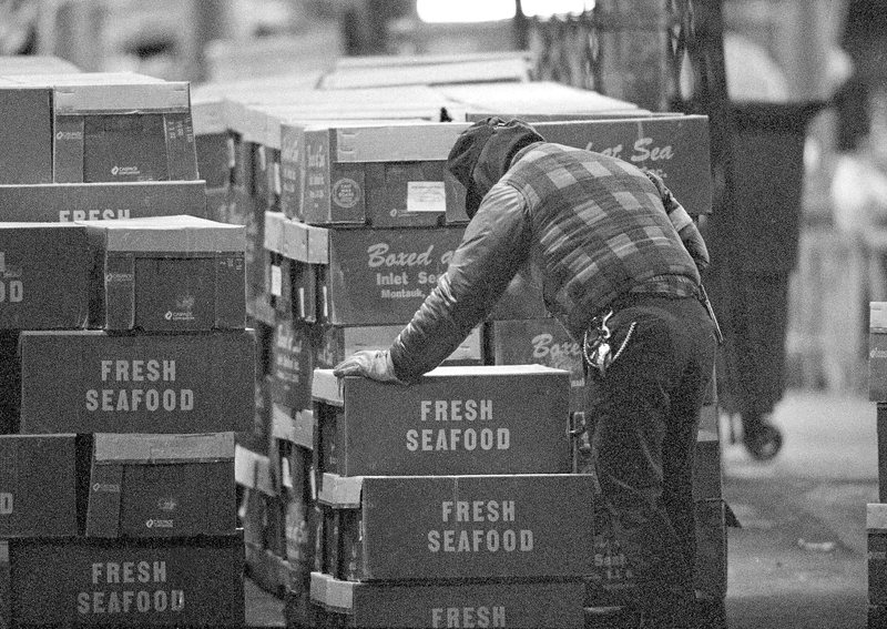 An unidentified worker unloads seafood at the Fulton Fish Market in New York City, in the early hours of March 24, 1992.