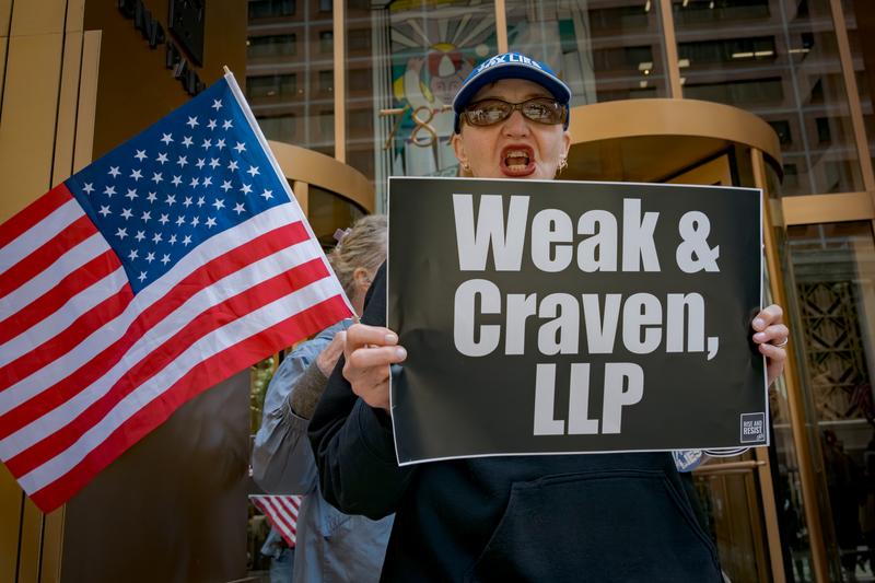 Participant seen holding a sign outside Willkie Farr law firm offices. Members and allies of the activist group Rise and Resist gathered outside NY-based law firms to protest their deals with Trump.th