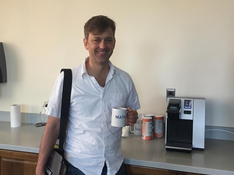 Picture of Jonathan Mattingly holding a coffee cup that says 'Math' on it.
