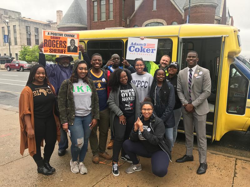 Picture of A T students in front of their school shuttle during Roll to the Polls.
