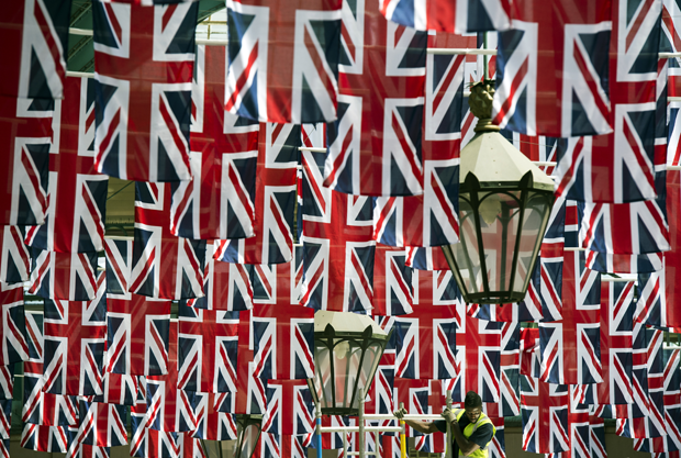 A construction worker stands on a platform amongst the Union Flags in the rafters of Covent Garden installed in honor of the Queen's Diamond Jubilee in London on May 30, 2012 (Adrian Dennis/AFP/Getty Images)