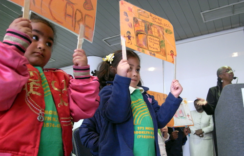 Children from the Audrey Johnson Day Care Center quietly protest city plans to close their school at hearing today.
