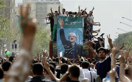 Monday's outpouring for Mousavi swelled as more people emerged from buildings and side streets wearing the trademark green of his campaign, following a decision by Iran's most powerful figure to investigate vote riggingallegations. (AP) 