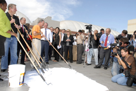 Bloomberg, Al Gore, and a small army of volunteers push around the eco-friendly white paint on the roof top of a Queens YMCA (photo by Jerry Speier).